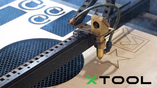 The xTool in action, engraving a check mark and star design. xTool logo